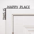 Wooden wall quote sign reading This is Happy Place installed in a corner of a room