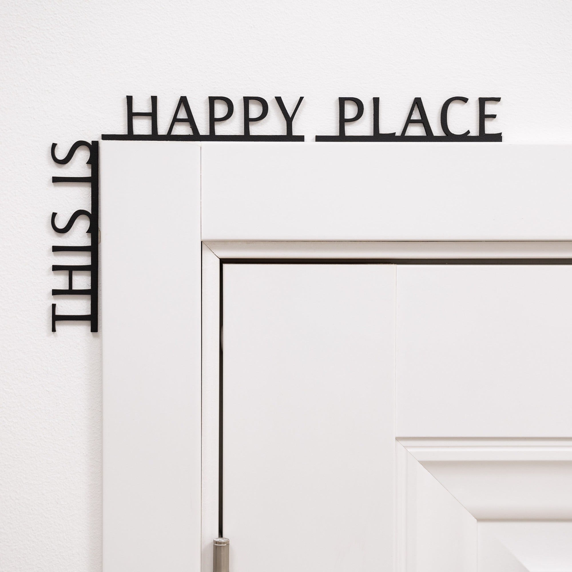 Wooden wall quote sign reading This is Happy Place installed in a corner of a room