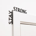 Minimalist black wooden wall art featuring the text Stay Strong.