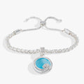 Silver bolo bracelet with a blue opal-colored charm and crystal-encrusted wave motif.