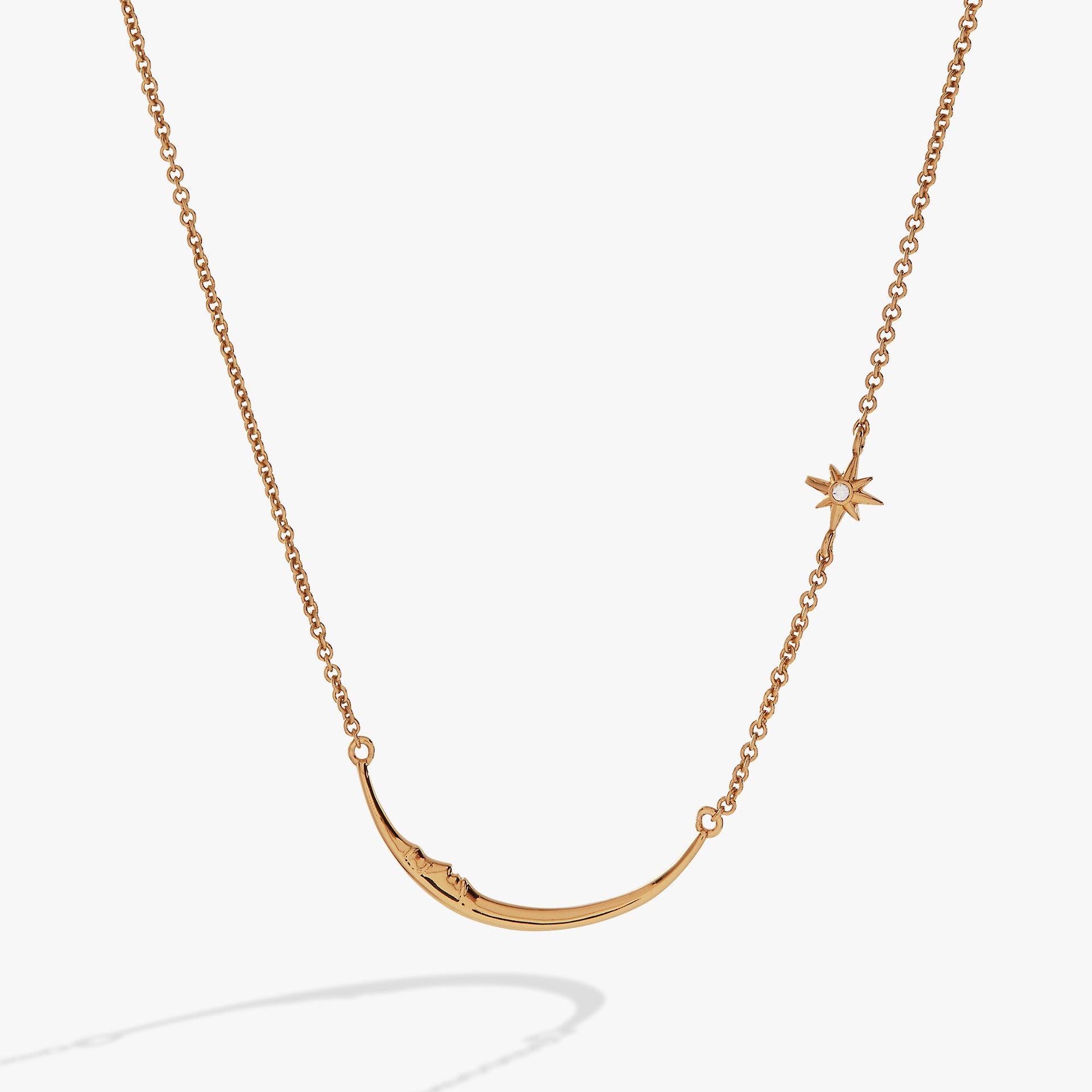 Delicate gold crescent moon pendant with a sparkling crystal star on a thin gold chain.