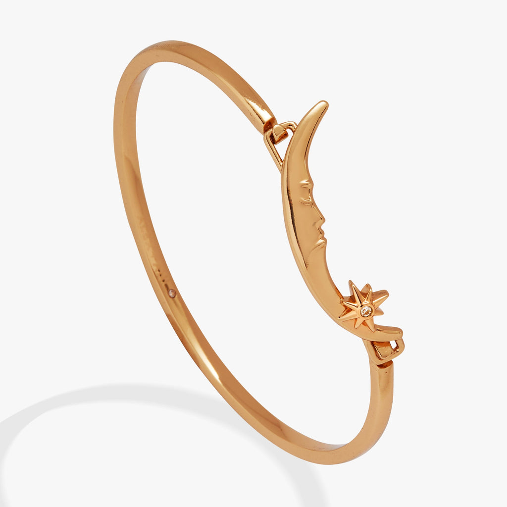 Gold crescent moon tension bangle featuring a crystal star detail on a white background.