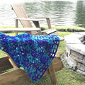 Finished crochet lap blanket draped over a chair showing textured stitch detail