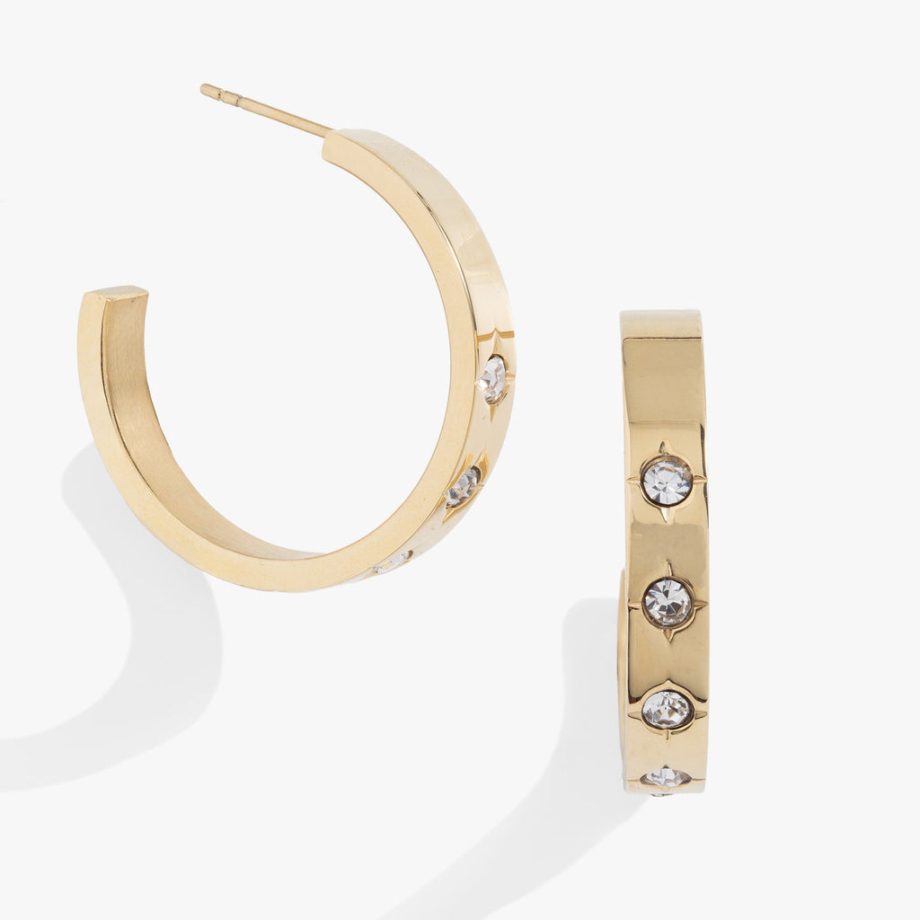 Gold hoop earrings featuring small crystal-centered star details for women.