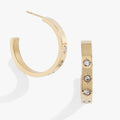Gold hoop earrings featuring small crystal-centered star details for women.