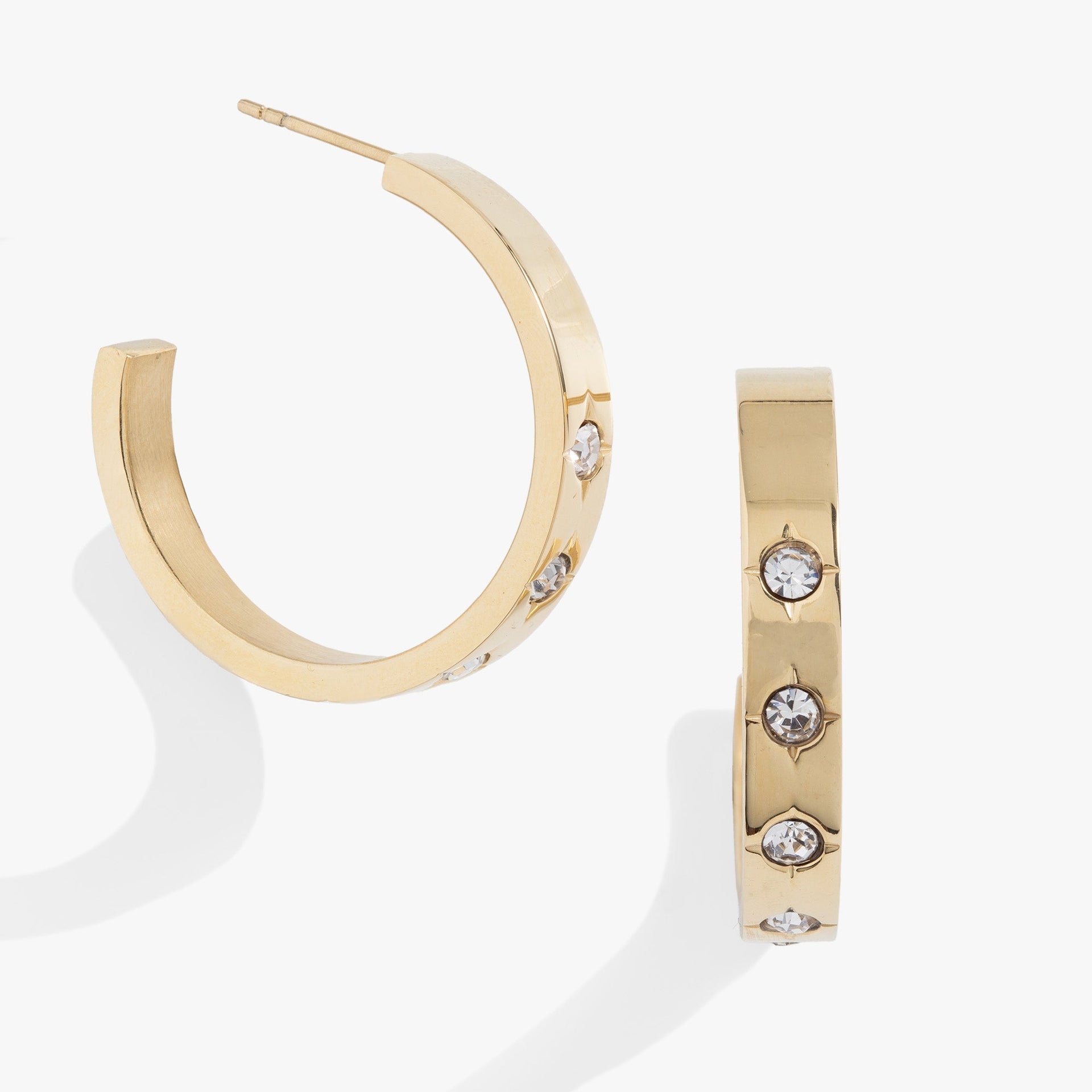 Gold hoop earrings featuring small crystal-centered star details for women.