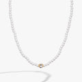 Crystal and white faux pearl beaded necklace with a clear square cube charm and gold accents