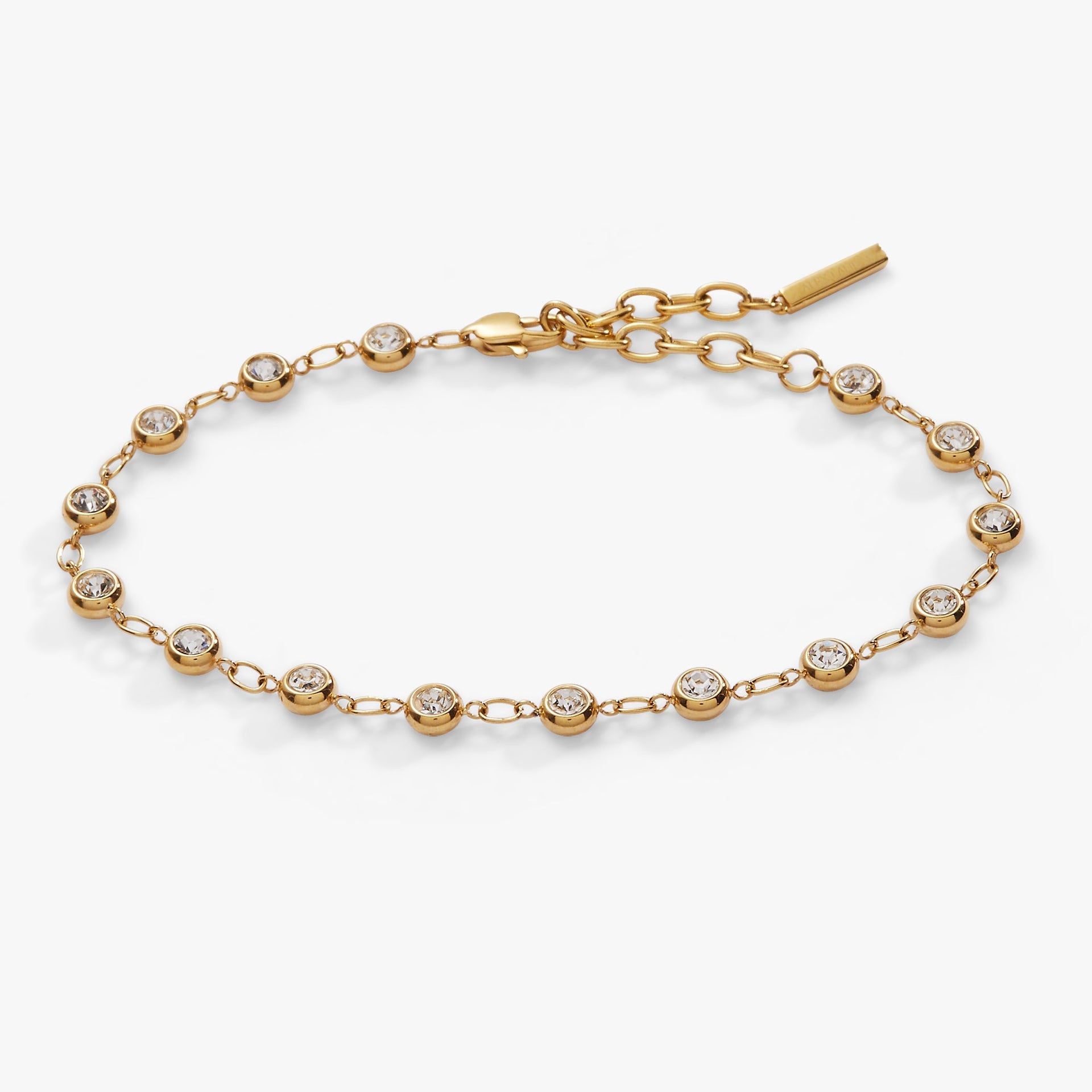 Close-up of a gold-tone cable chain bracelet with round clear crystals in bezel settings.