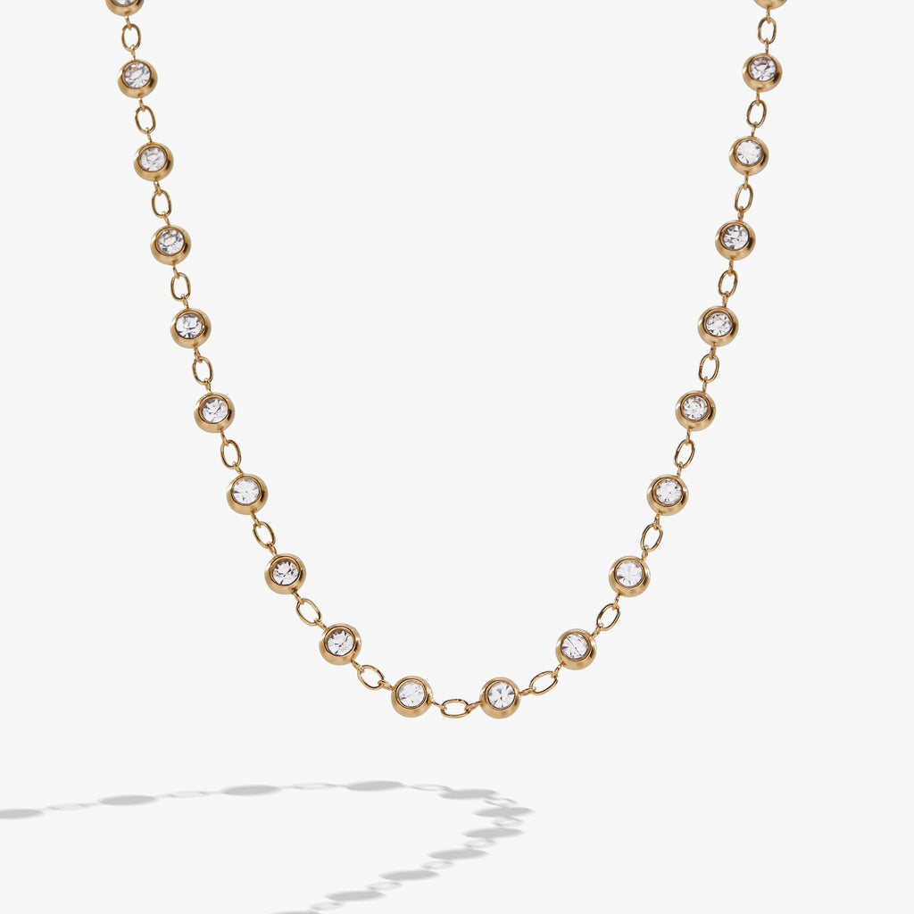 Gold-tone chain necklace featuring alternating clear crystal pebbles and polished links.