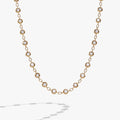 Gold-tone chain necklace featuring alternating clear crystal pebbles and polished links.