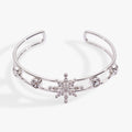 Silver openwork cuff bracelet with a prominent crystal snowflake and pave stone details.