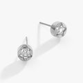 A pair of minimalist silver-tone star stud earrings with clear crystals on a white background.