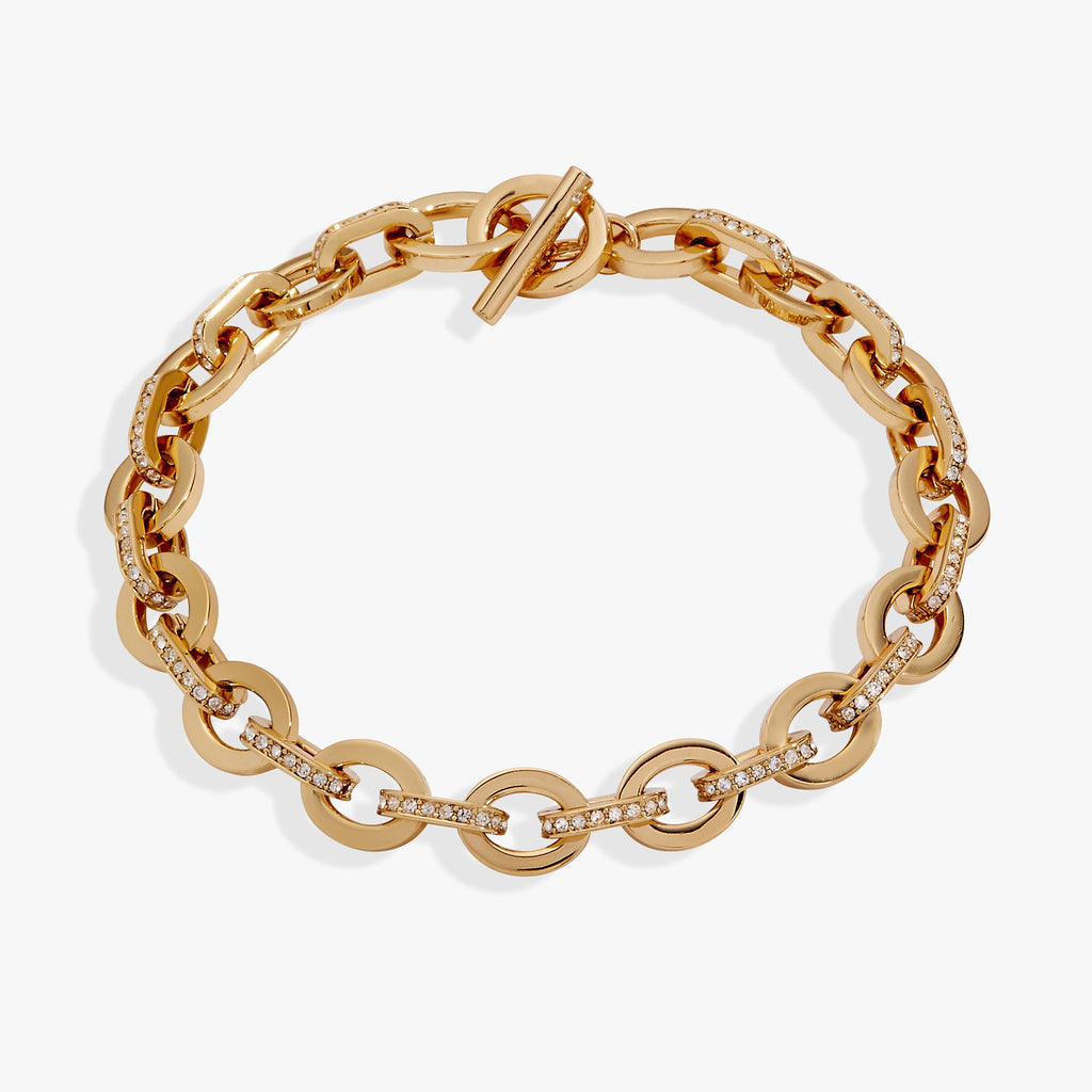 Close-up of a delicate oval link toggle bracelet paved with sparkling crystals.