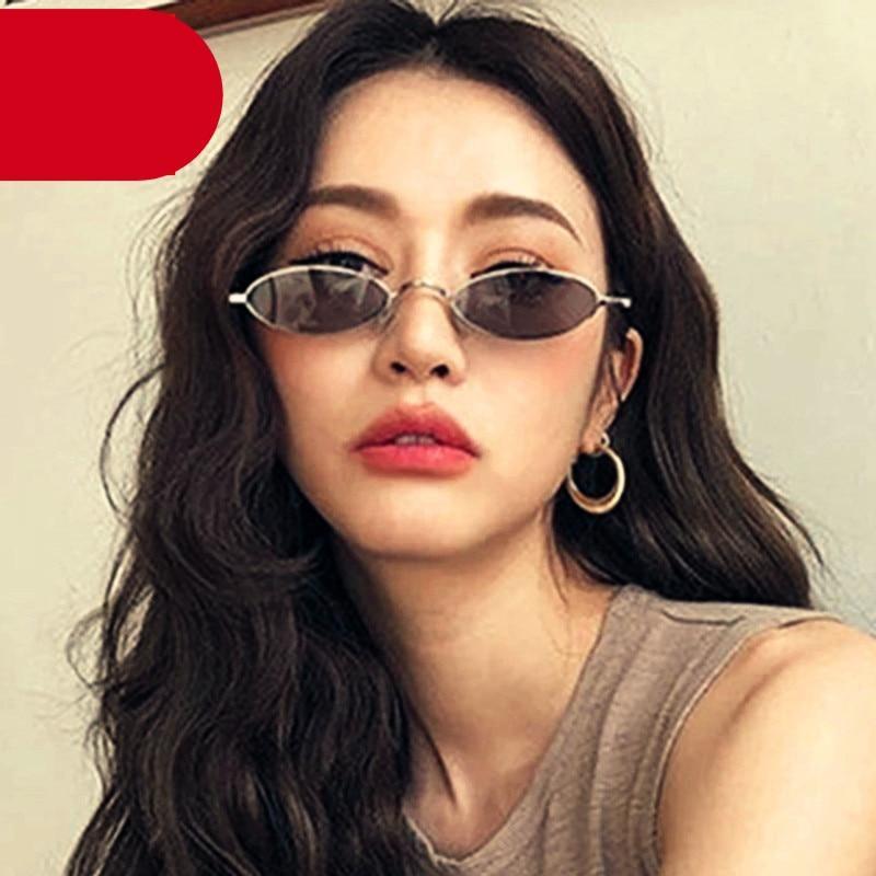 Small black oval sunglasses with slim metal frame and adjustable nose pads
