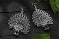 Oxidised silver-toned peacock motif earrings for traditional and ethnic wear