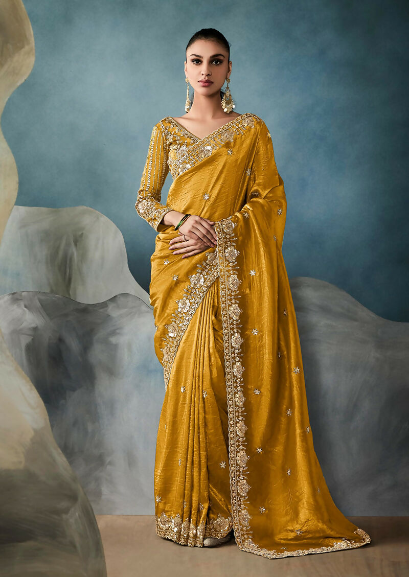 Vibrant mustard tissue saree adorned with intricate sequins and zari work.