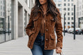 A woman wearing a brown retro-style suede jacket with multiple pockets and a lapel collar.