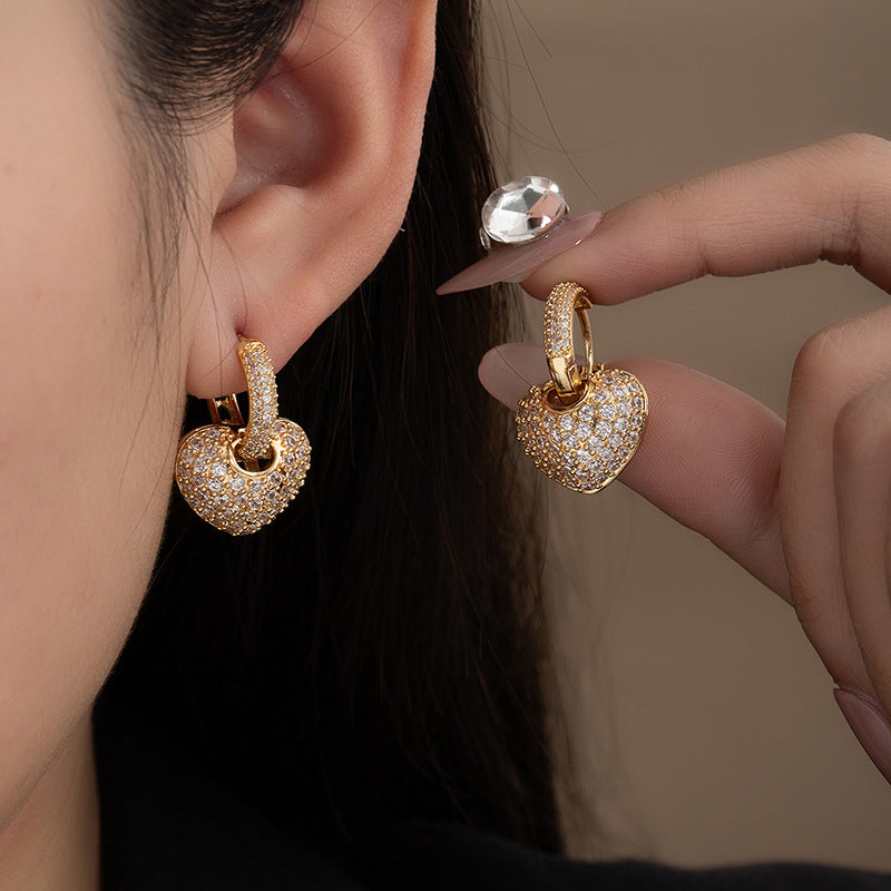 Elegant gold-tone heart-shaped statement earrings featuring pave-set white cubic zirconia crystals.