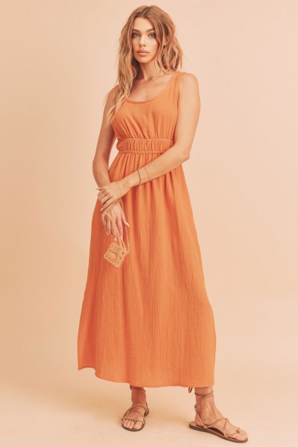 Woman wearing a sleeveless round neck maxi tank dress with a side slit for a casual summer look