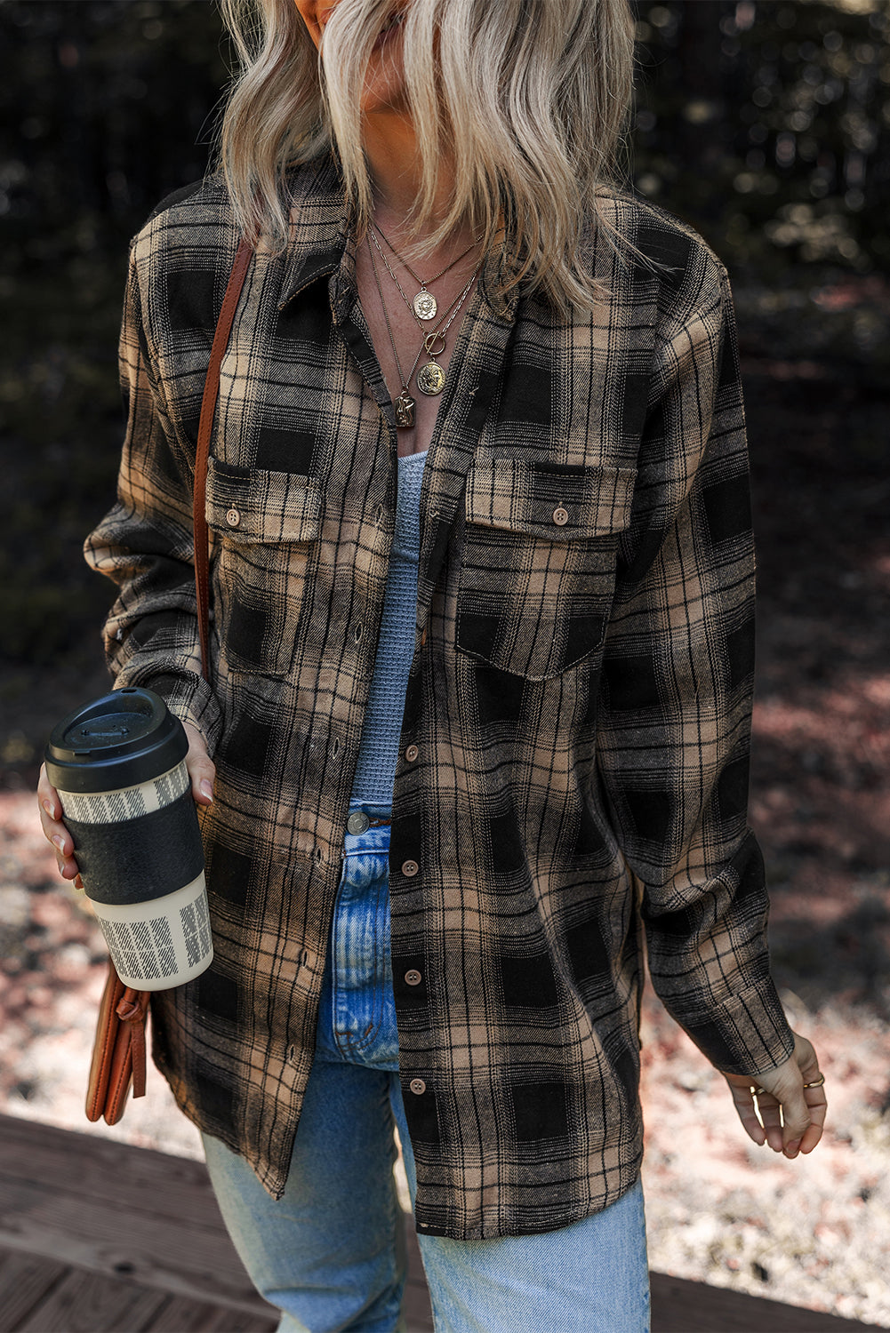 Woman wearing a tan and black plaid brushed shacket with functional pockets in a casual outdoor setting