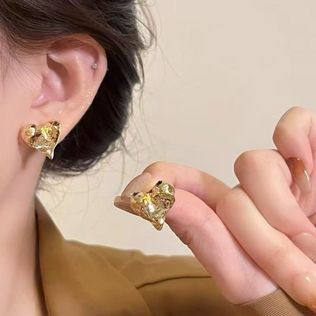 Close-up of minimalist tiny gold heart studs for women