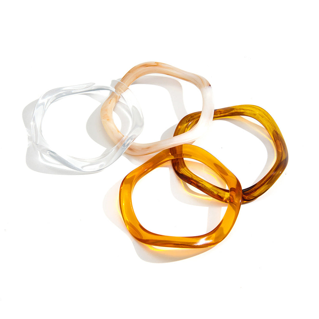 Polished transparent acrylic resin wave bracelet in clear, beige, and amber tones