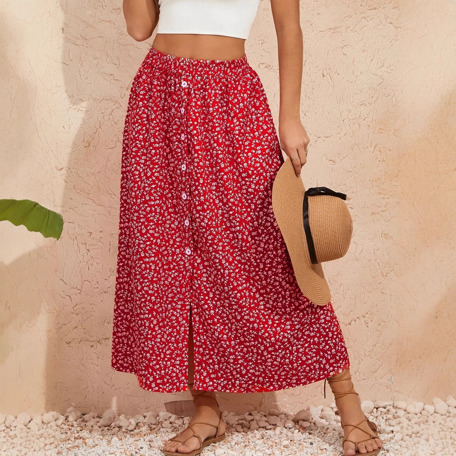 Woman wearing a floral print A-line skirt with a self-tie waist in a pastoral setting