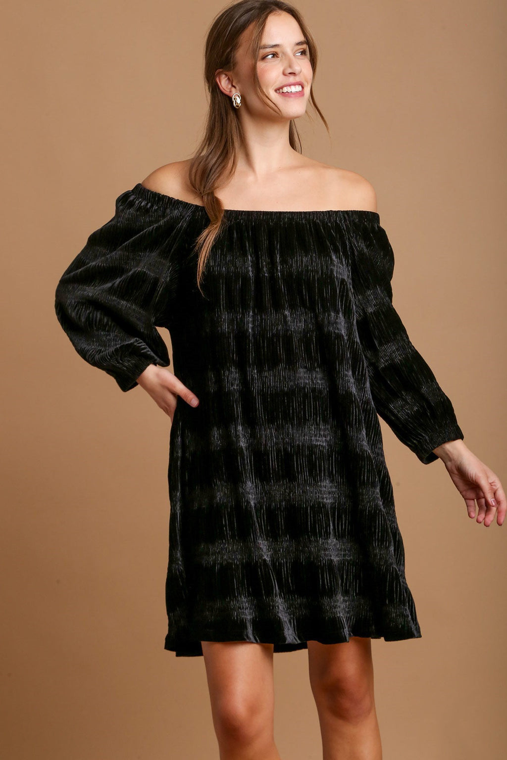 Model wearing a luxurious black off-shoulder velvet mini dress with dramatic balloon sleeves