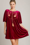 Luxurious velvet mini dress featuring elegant embroidery and tassel accents.