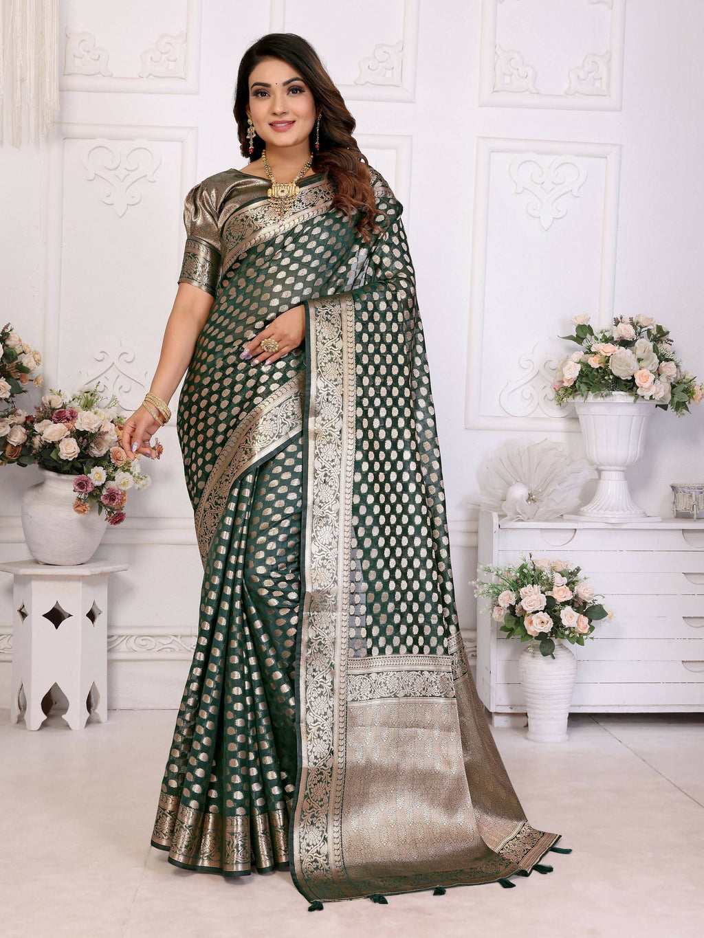 A deep dark green organza silk saree with detailed weaving.
