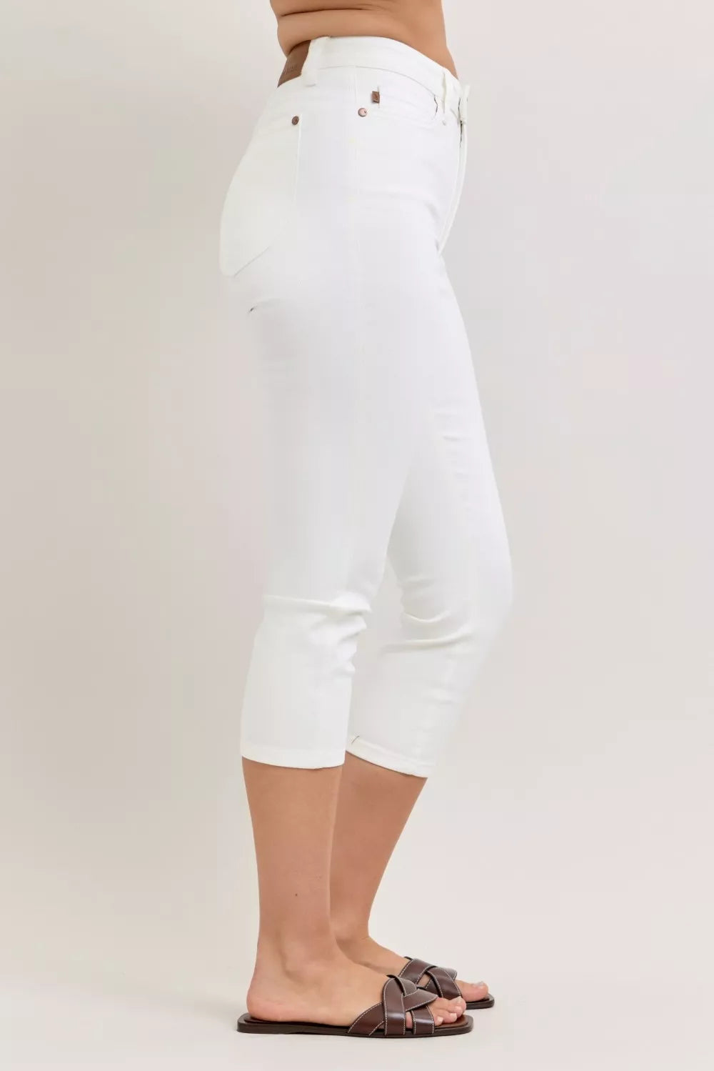 White capri pants worn by a person on a plain background