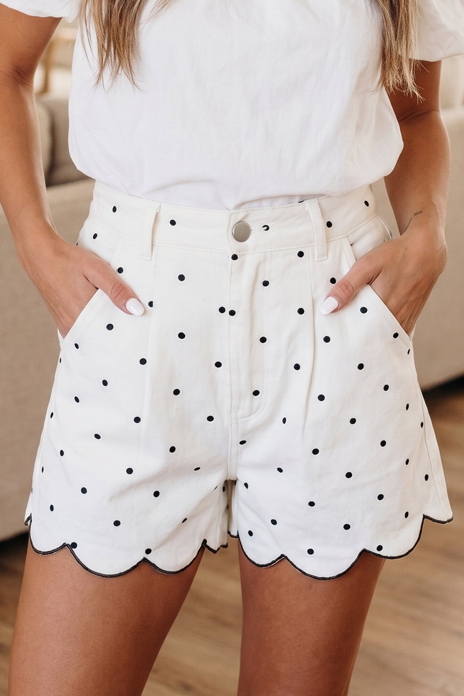 Close up of Elise polka dot denim shorts with embroidered scallop hem in white and black