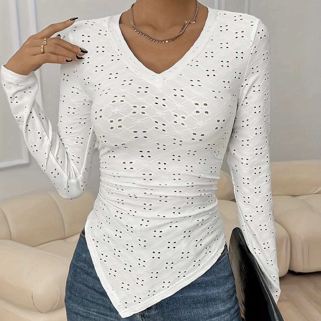 A woman wearing a white, long-sleeve, hollow-out v-neck top with a pointed hemline.