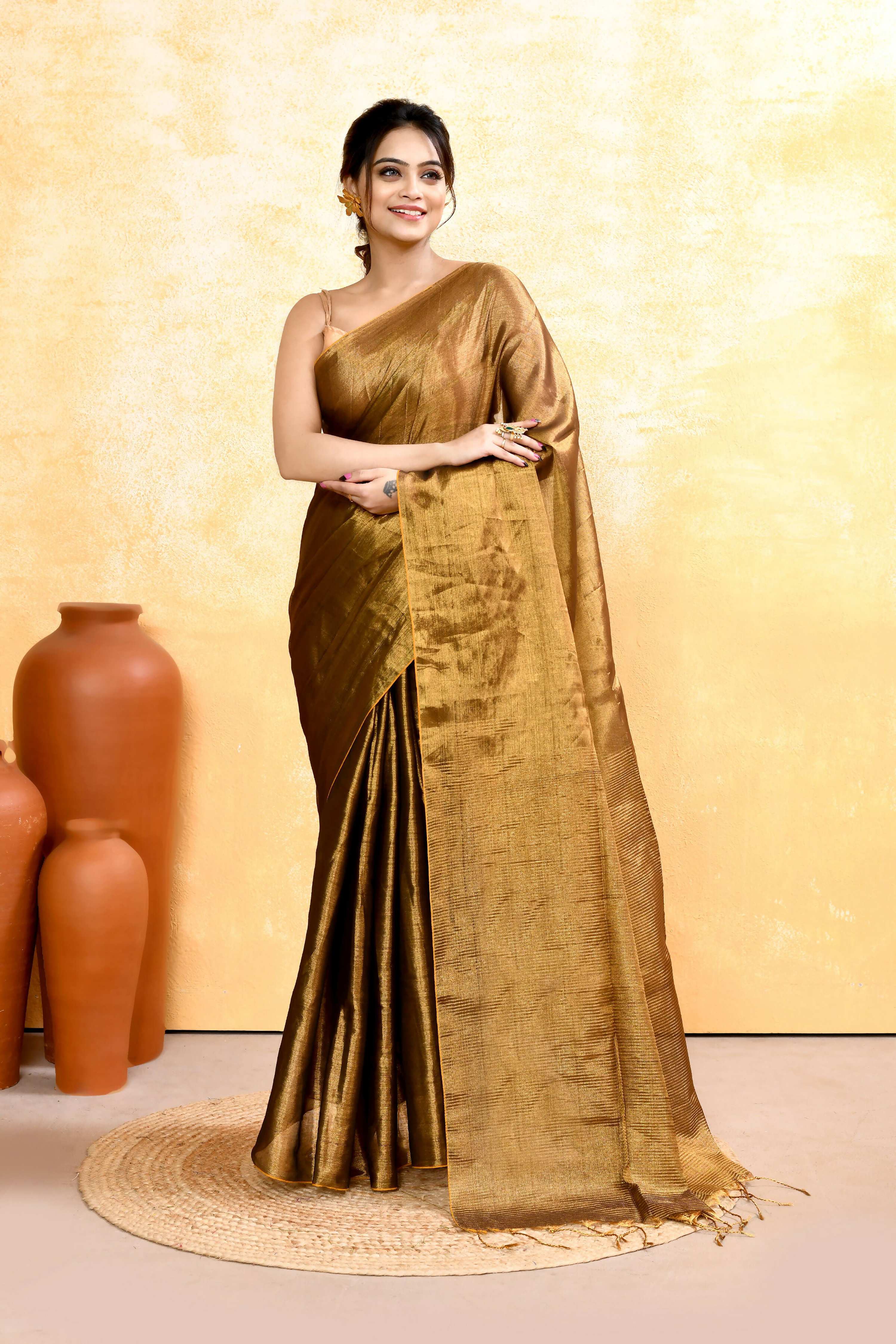 Woman wearing a gold dual-tone organic tissue saree with matching blouse piece