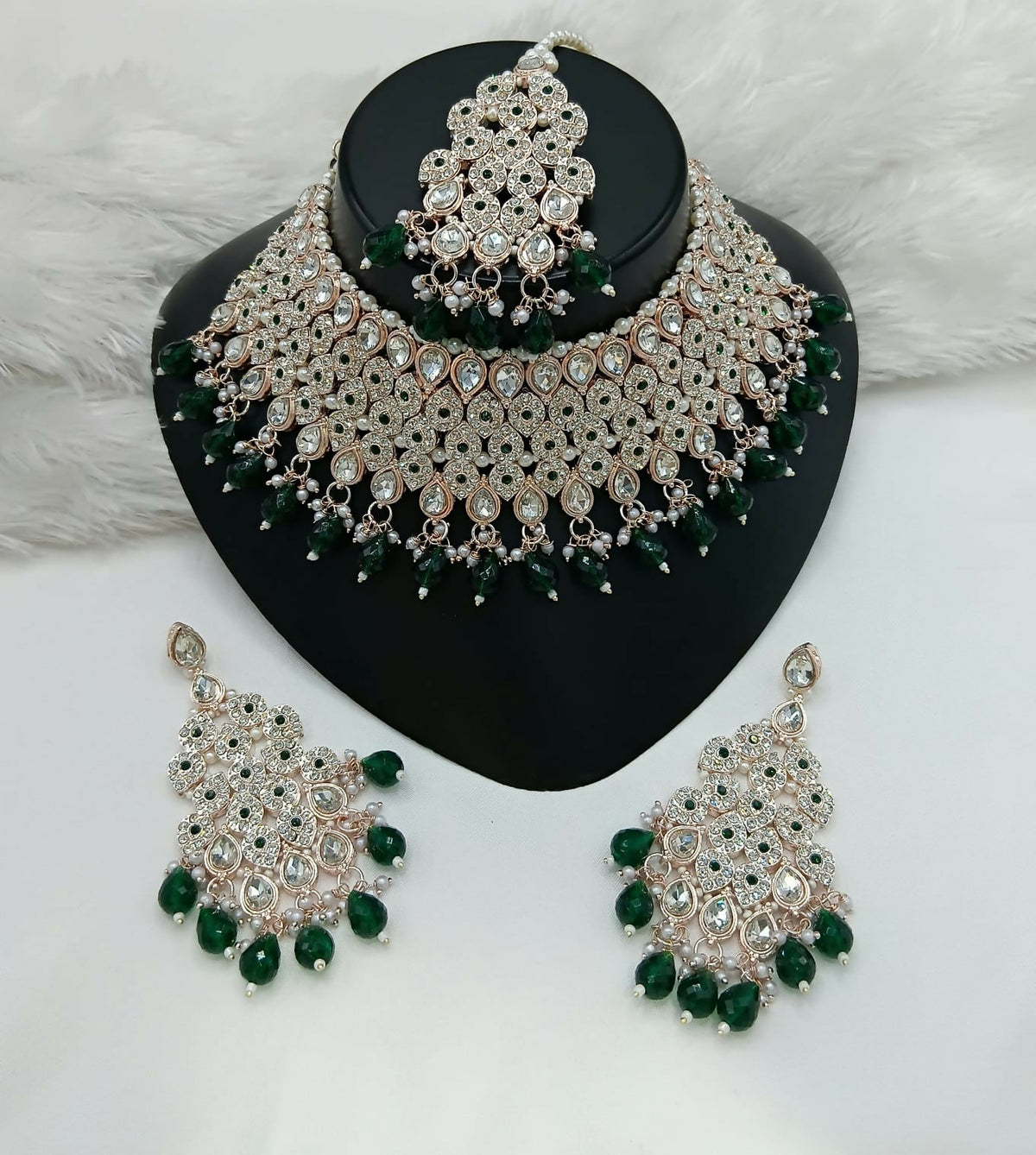 Dista women's brass necklace set with vibrant green stone work and matching earrings and tikka