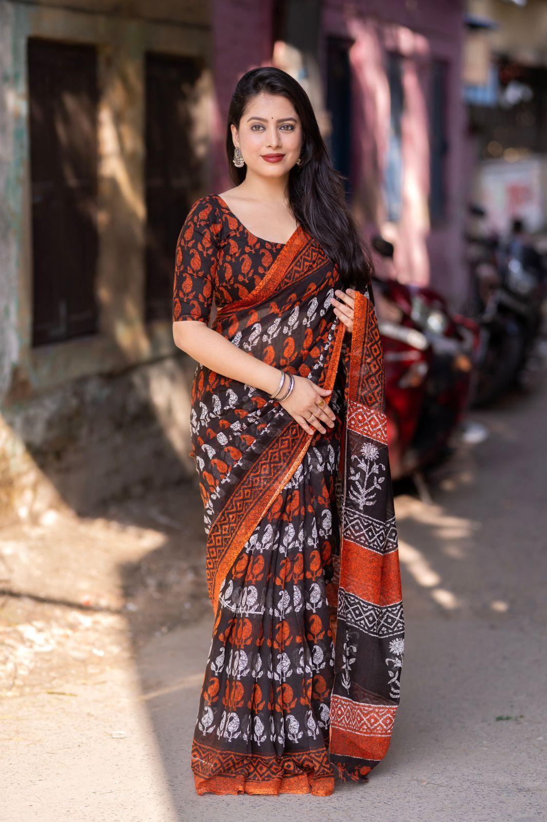 Bright orange linen blend saree with ethnic motifs and matching unstitched blouse
