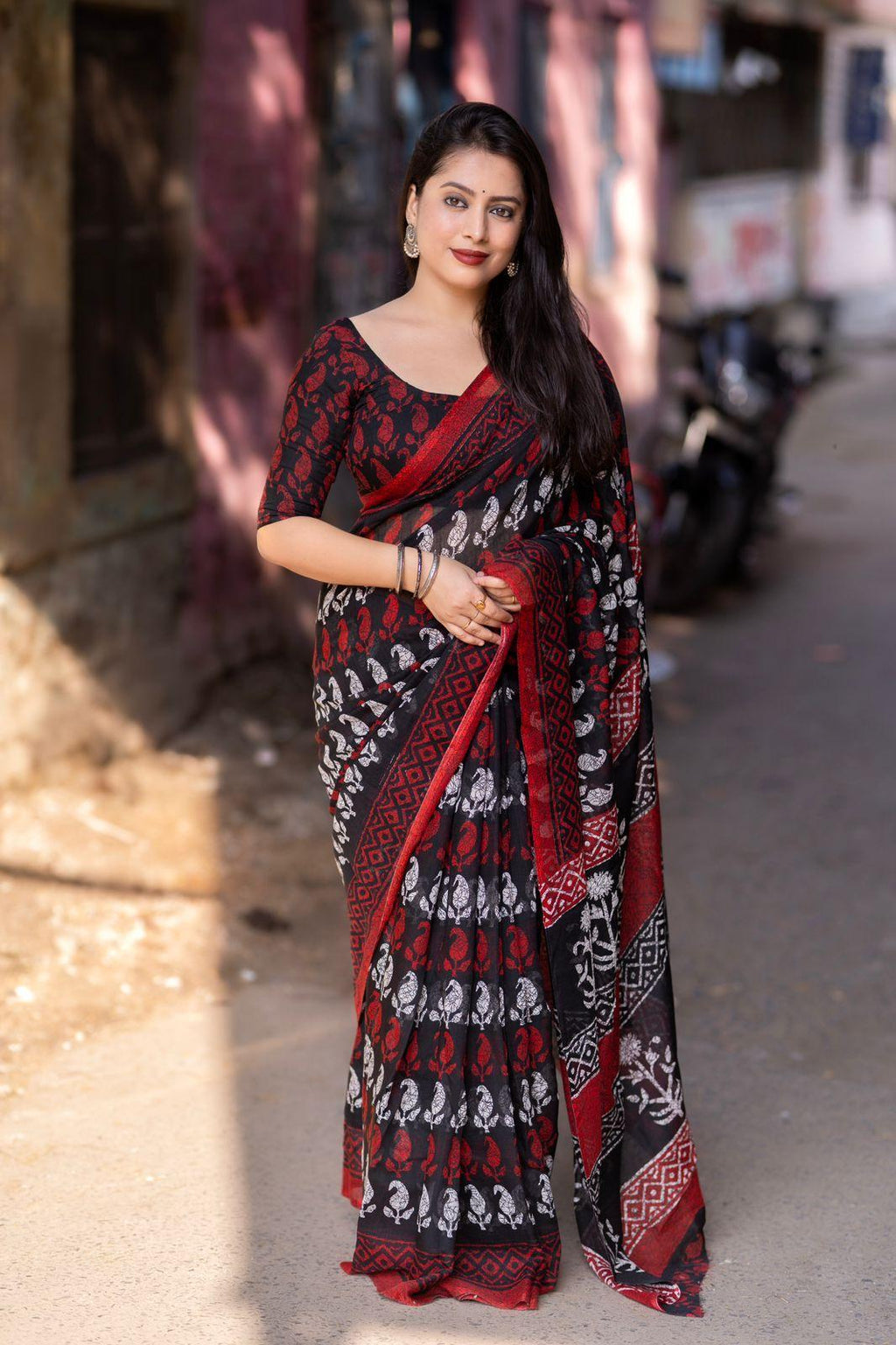 Red linen blend saree with ethnic printed motifs and matching running blouse.