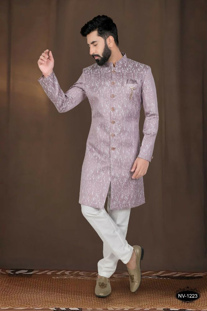 A toddler wearing a pink woven jacquard kurta with white pyjamas for a festive occasion