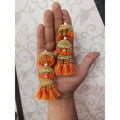 Gold-toned jhumka earrings featuring orange pearls and intricate silk thread work