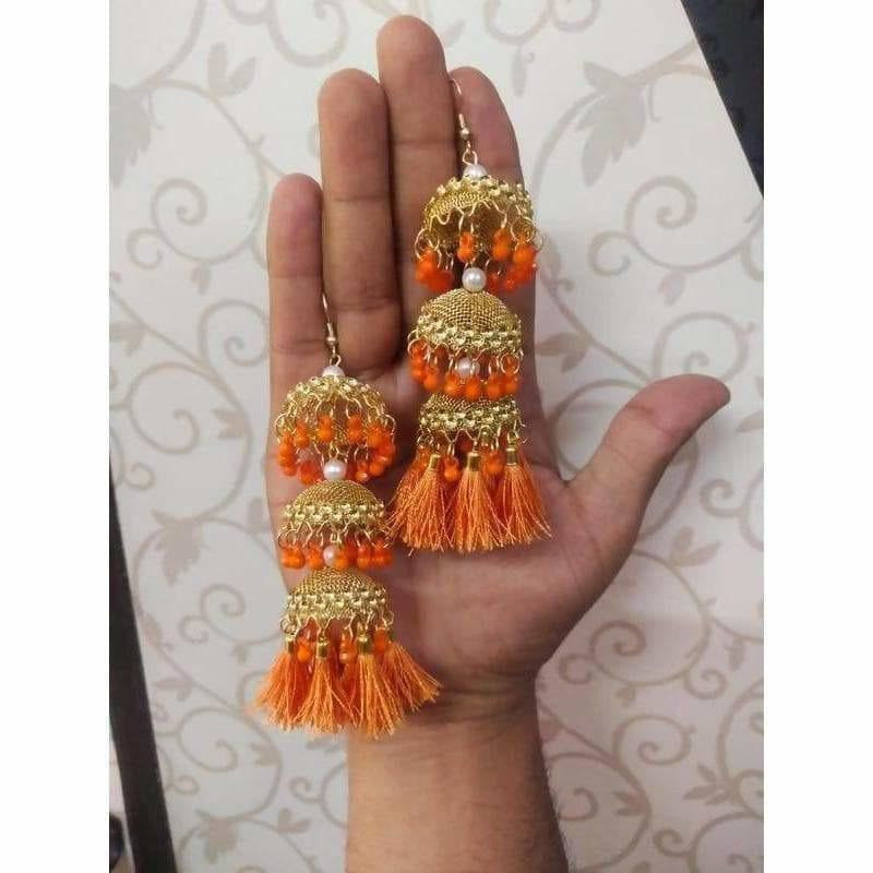 Gold-toned jhumka earrings featuring orange pearls and intricate silk thread work