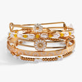 Set of five gold-toned bohemian bangles featuring daisy flower charms, beads, and floral patterns.