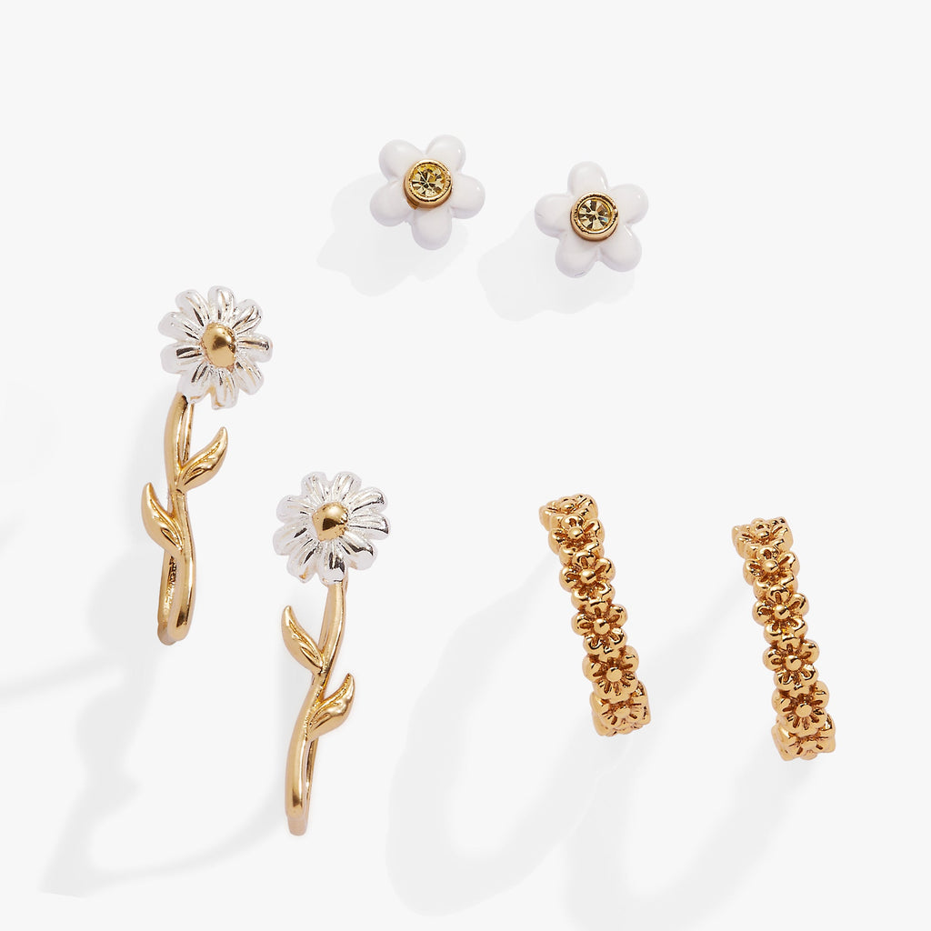 A 3-piece jewelry set featuring daisy-themed stud earrings, huggie hoops, and an ear climber in gold and white tones.
