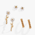 A 3-piece jewelry set featuring daisy-themed stud earrings, huggie hoops, and an ear climber in gold and white tones.