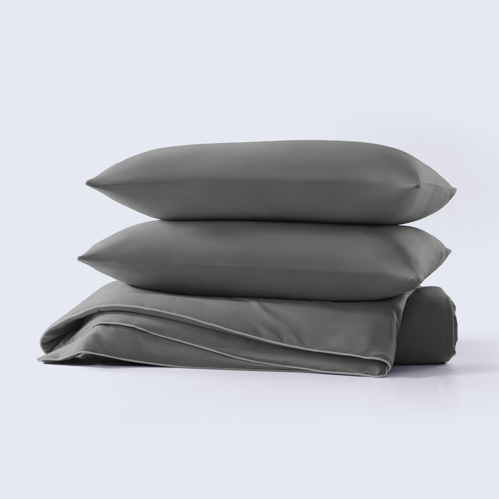 A grey cooling comforter set with matching pillows presented on a neutral background.