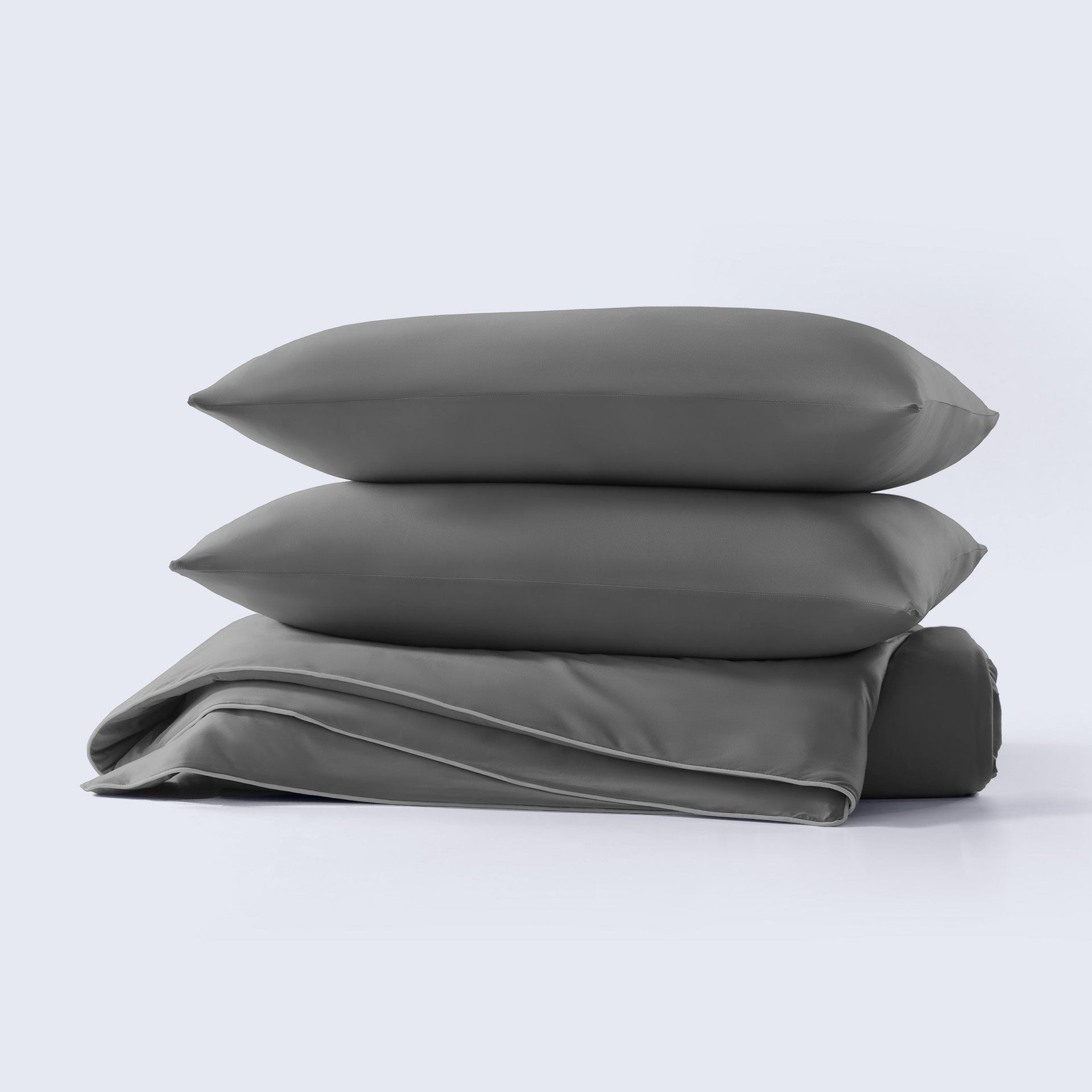 A grey cooling comforter set with matching pillows presented on a neutral background.