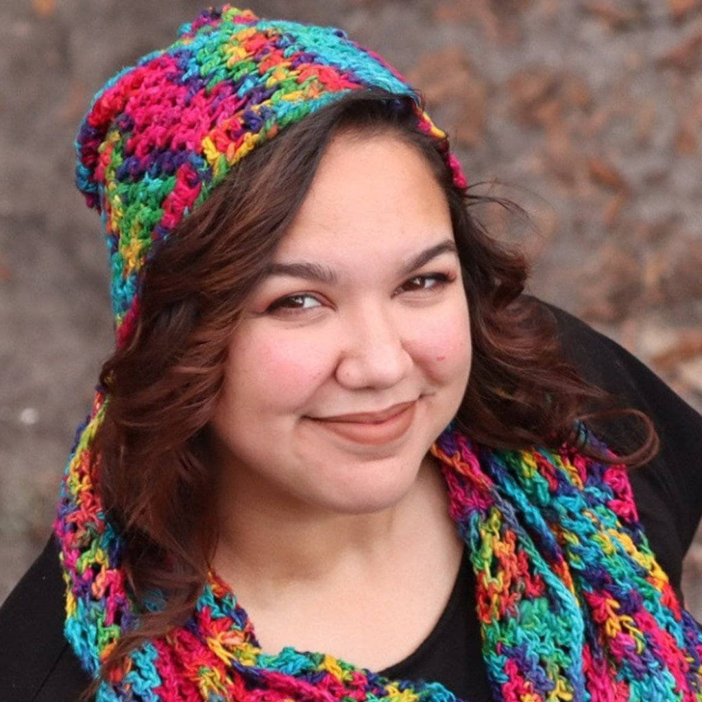 A woman wearing a vibrant, multi-colored ripple slouch hat with a bohemian aesthetic.