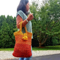 Darn Good Tote Bag kit featuring skeins of yellow, orange, and red yarn