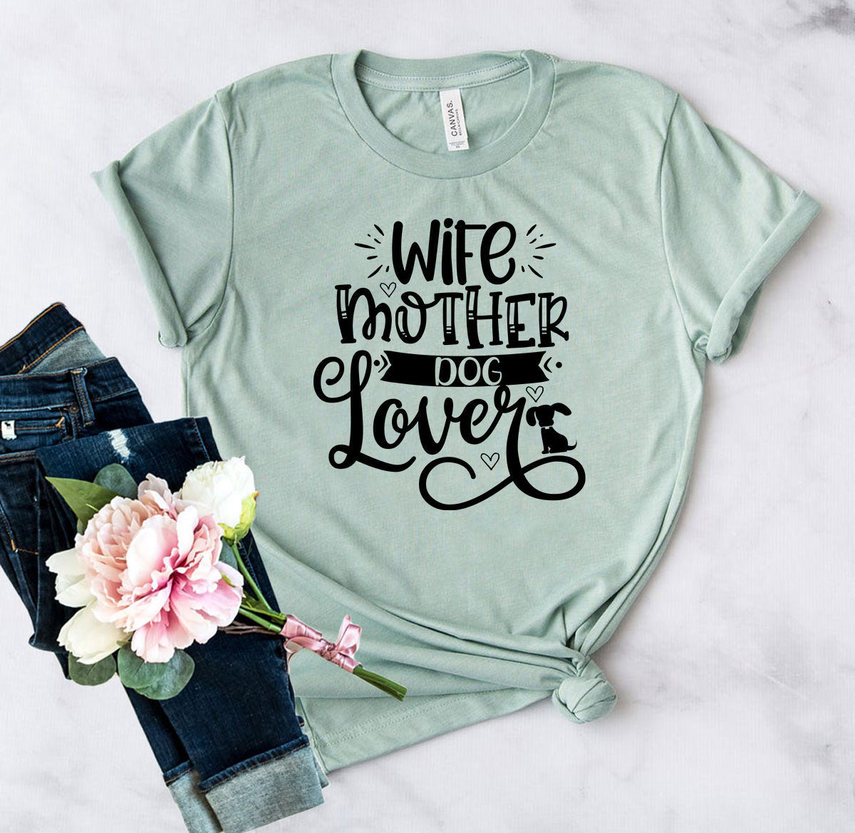 A sage green t-shirt with black text that reads Wife Mother Dog Lover.