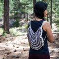 Close-up of a handmade crochet bag featuring a colorful mandala design with adjustable strap knots.