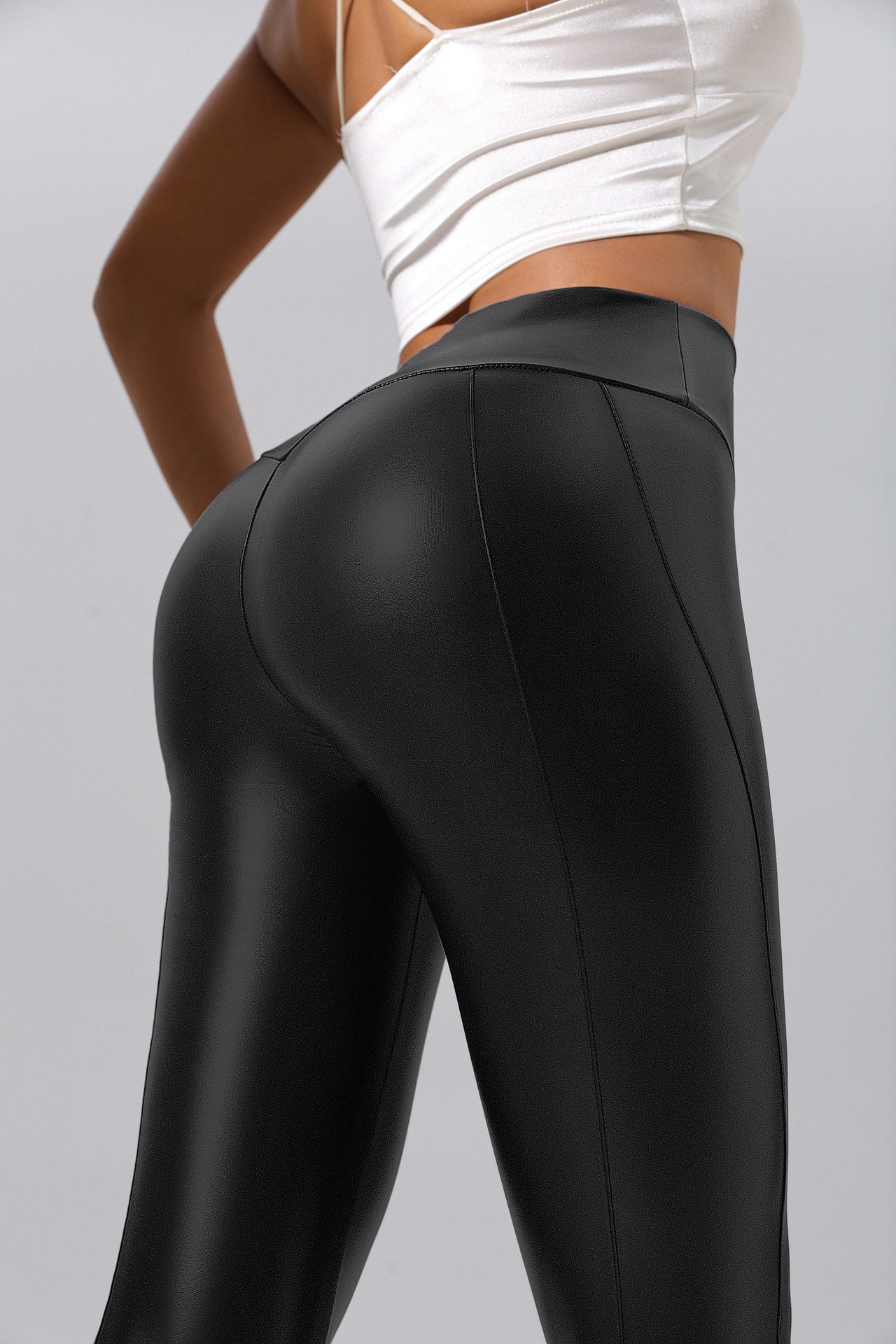 Model wearing black patchwork faux leather activewear leggings with high waistband